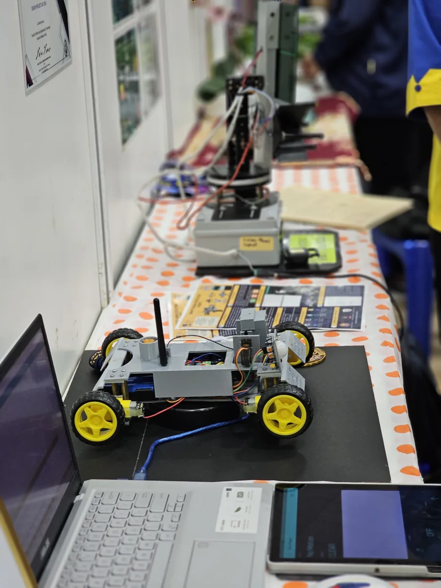 Small wheeled engineering prototype on an exhibition table.