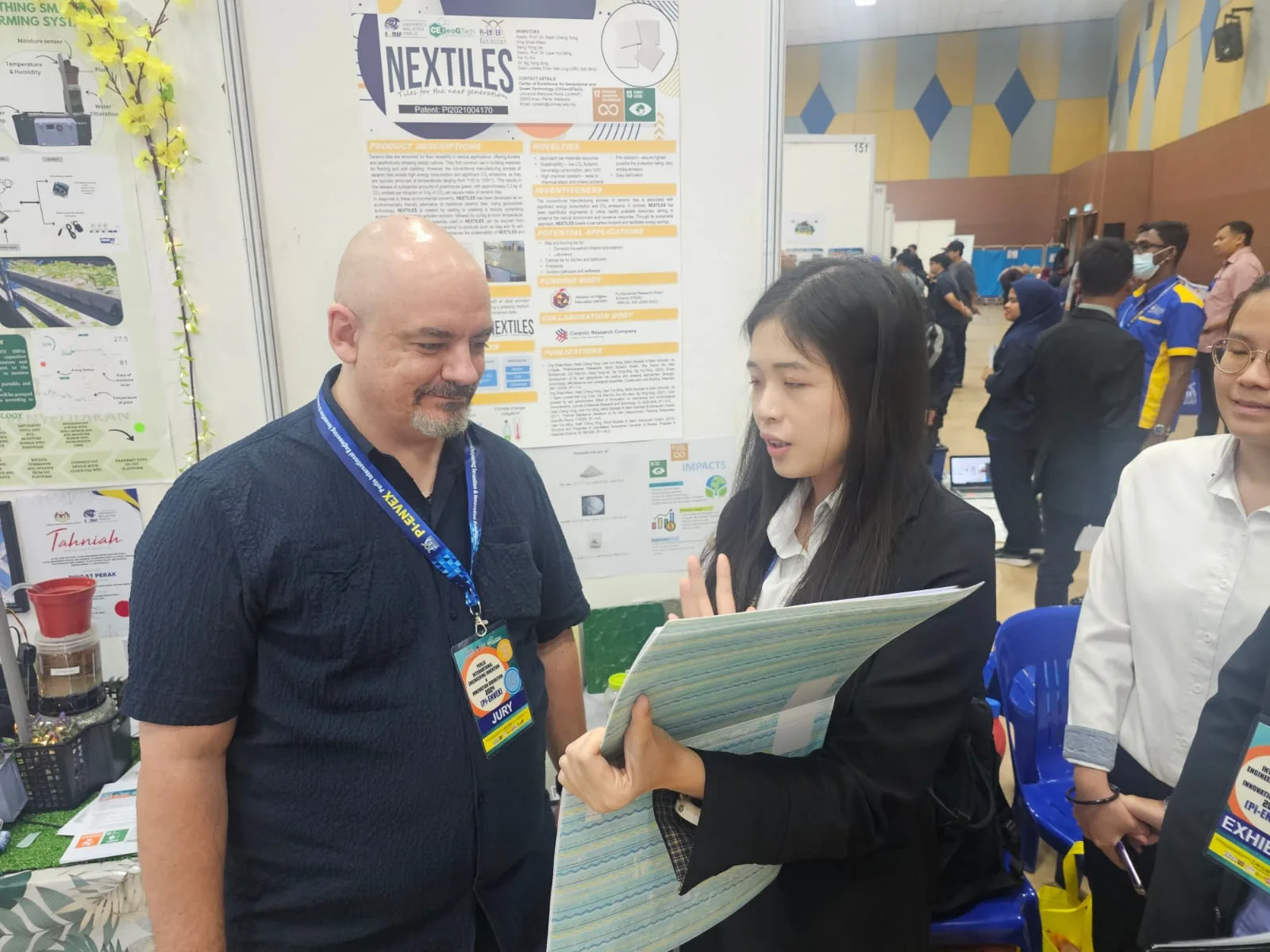 Three people discussing an innovation at the exhibition.