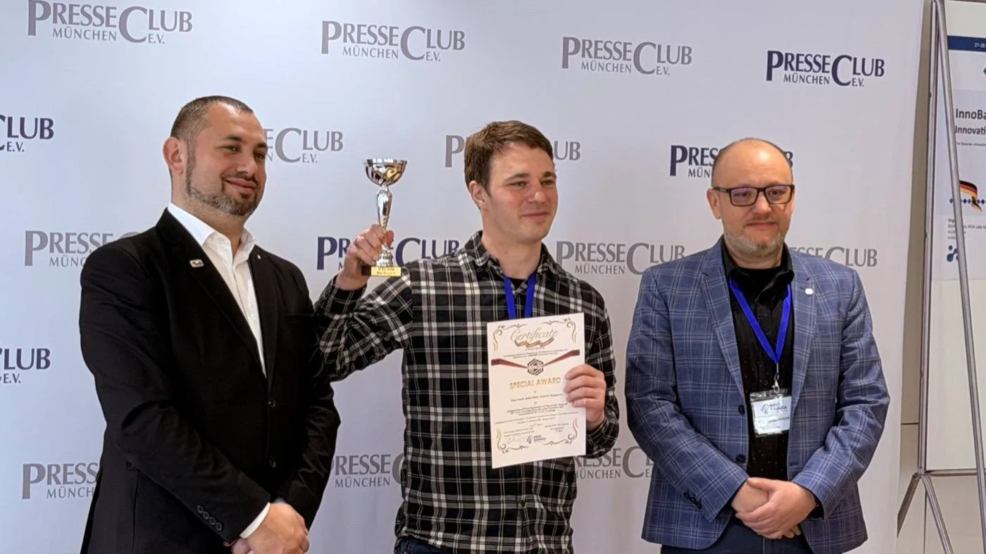 An award recipient holding a trophy and certificate with organisers.